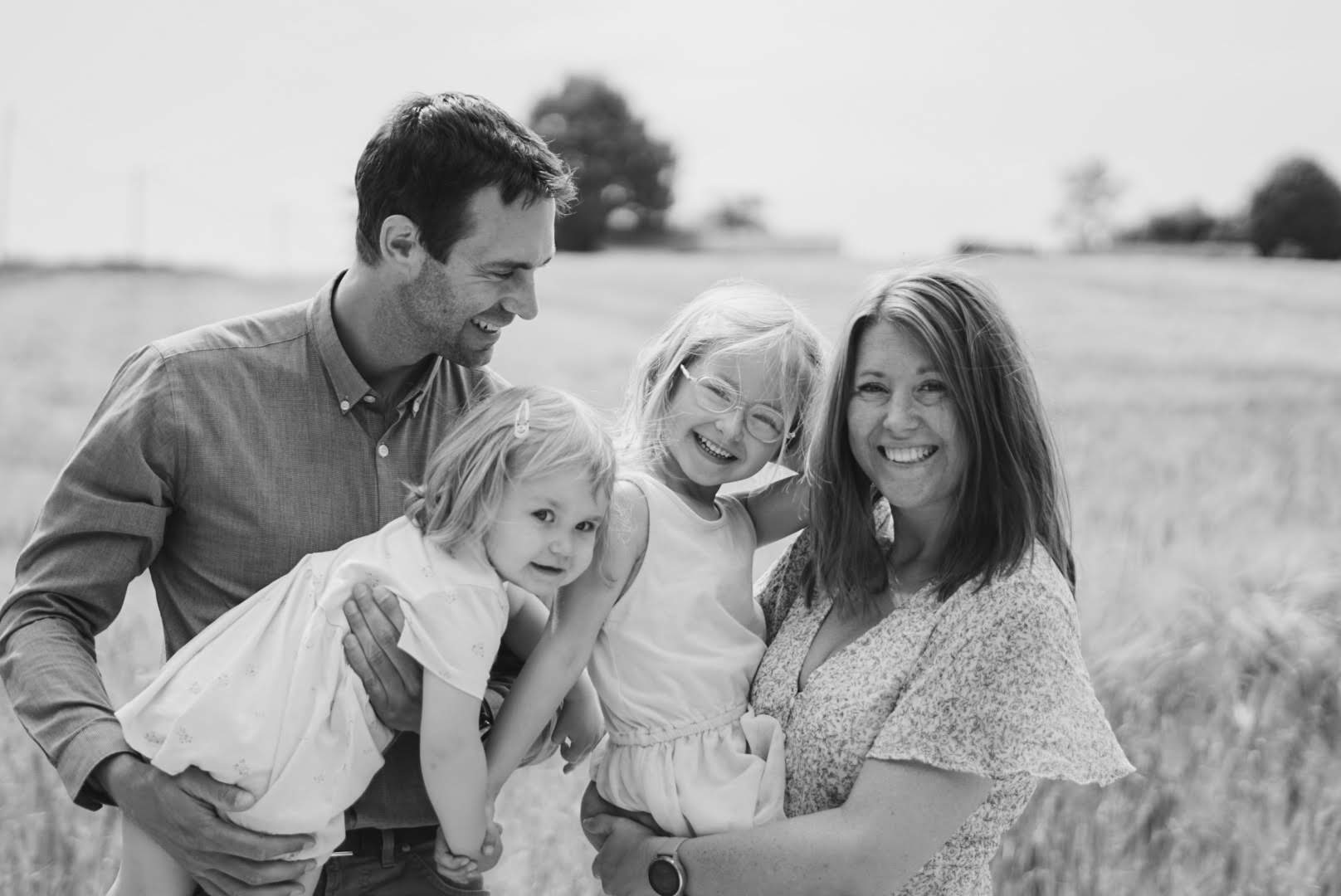 Foto van een prachtig gezin tijdens een familie fotoshoot in een mooi veldje. Herinneringen voor het leven